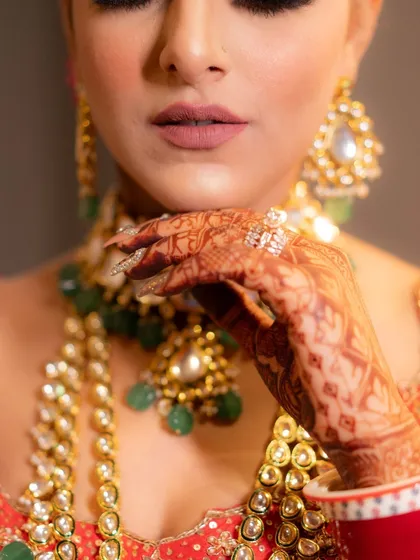 A close-up on the bride's hands and jewelry. This detail shot highlights the beauty and intricacy of her bridal look, a key part of the wedding story.
