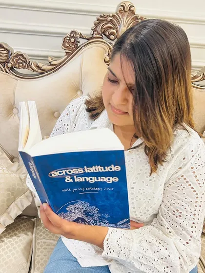 A reader enjoying 'Across Latitude & Language.' This book, featuring over 100 poets from around the world, is a must have for any poetry lover and is available for purchase on our website.