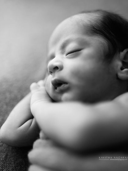 This black and white close-up of a nine-day-old newborn highlights the delicate, sleepy features that are so characteristic of the first ten days. Booking your session early helps capture this fleeting peace.