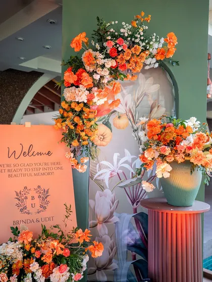 The full welcome setup for a Goa wedding, featuring a personalized sign and lush, colorful floral arrangements.