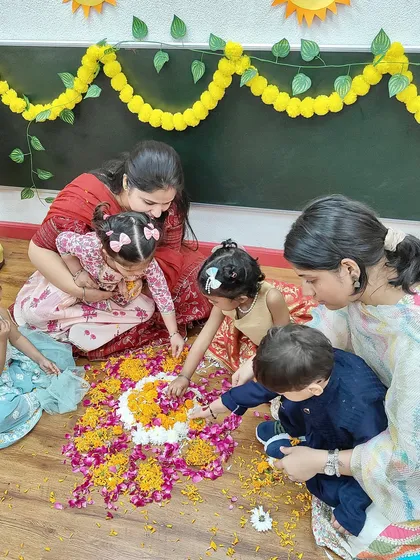 Teamwork makes the dream work. Children and teachers collaborate to create a beautiful flower rangoli on the floor for Diwali.