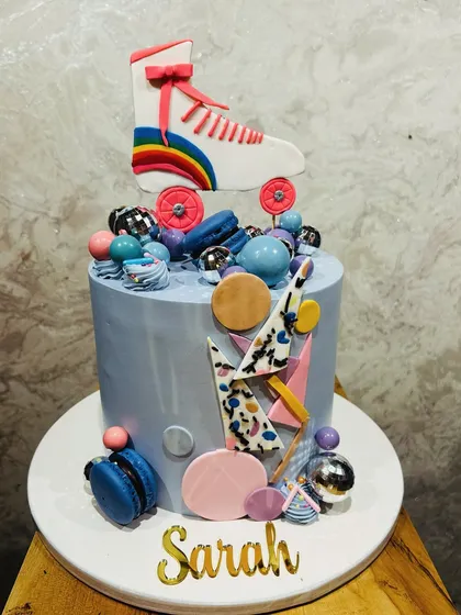 A retro and fun roller skate-themed cake, with a fondant skate on top and colorful 80s-style decorations.
