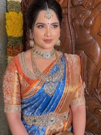 Another view of the bride in her blue and orange saree, showcasing the opulent look created by the custom brocade blouse and diamond jewelry.