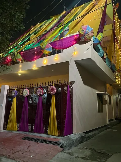 The combination of purple and yellow drapes on the gate, accented with large flower bunches.