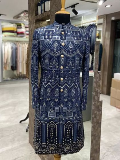 A longline Indo-Western sherwani in blue with a geometric print. This is a modern and stylish option for a wedding guest or for a pre-wedding function.