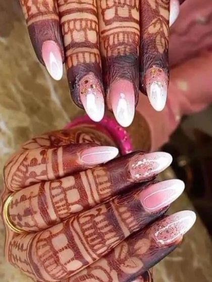 A beautiful set of ombre nails on henna-adorned hands, showing how we can complement your festive look.