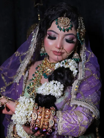 A beautiful candid moment showing the detailed embroidery on the blouse and the delicate floral accessories in the hair.