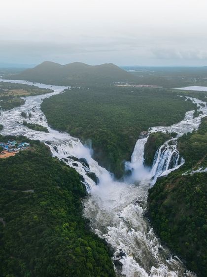 The Kaveri river splits to form the majestic Shivanasamudra falls. This aerial perspective shows the sheer scale of this natural wonder in the Mandya district.