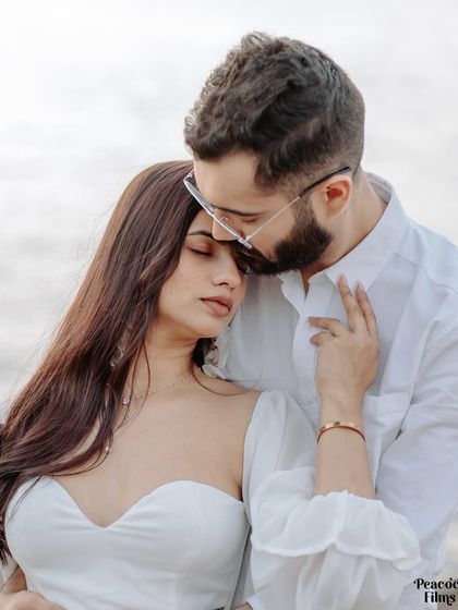 A gentle kiss on the forehead against the soft light of the sea. This pre-wedding portrait is a testament to the quiet, tender moments that define a deep and meaningful love.