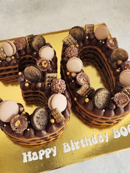 A decadent chocolate cream tart cake for a 30th birthday. This one is loaded with Ferrero Rocher, Oreos, macarons, and chocolate bars.