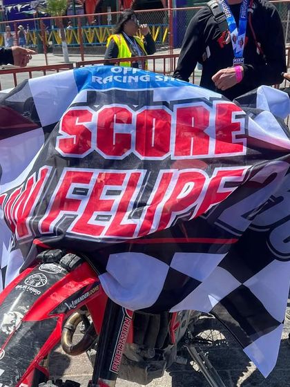 The race bike draped in the official SCORE San Felipe checkered flag. This represents the culmination of months of preparation and a grueling day of racing.