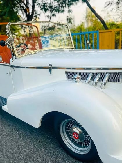 Arrive in timeless style with our classic vintage car, available for rent. This white convertible with tan leather interiors is perfect for a royal groom's baraat or a stylish couple's entry.
