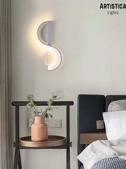 This abstract, S-shaped LED wall lamp is a piece of illuminated art. Its sculptural form provides a soft, indirect light, making it an ideal choice for a modern bedroom or a creative living space.