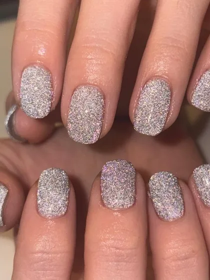 A full-coverage, dazzling silver glitter manicure. This light-reflective polish creates an incredible disco-ball effect on the nails.
