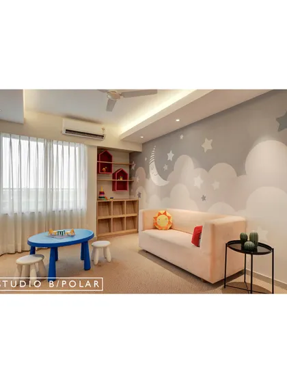 Another playroom design featuring a dreamy cloud and stars wallpaper. A soft pink sofa and a child-sized table and stools create a perfect spot for creative activities and quiet time.