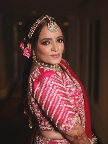 A side profile showcasing the elegant hairstyle with fresh flowers and the glowing skin finish we achieved for this bridal look.