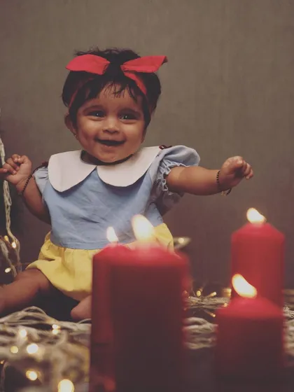 A little Snow White enjoying the Christmas season. The warm glow of the candles and fairy lights creates a magical and cozy atmosphere for this festive portrait.