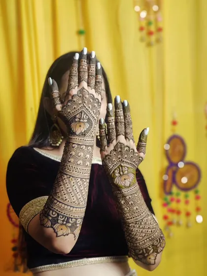A lovely back-of-hand design with lotus motifs and intricate bands. The pose really shows off the full length and detail of the work.