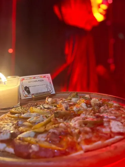 A 'Witches Pizza' served under dramatic red lighting for a Halloween party. This shows my commitment to creating a spooky and fun ambiance through both creative food naming and atmospheric presentation.