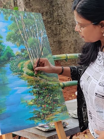 A focused moment, carefully painting the details of the foliage along the lake's edge.