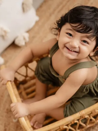 A heart-melting smile from the birthday boy. This close-up shot in a wicker basket perfectly captures his happy and playful personality.