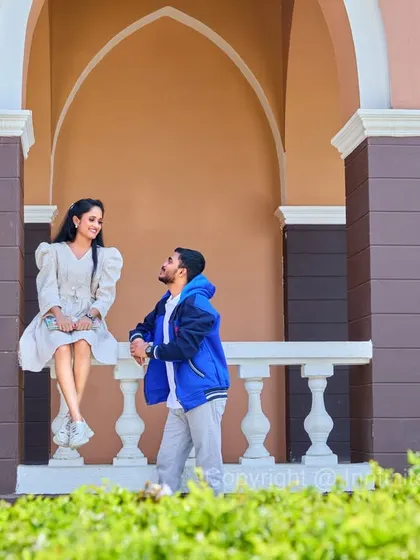 A relaxed portrait on a balustrade, showcasing a modern architectural backdrop for a stylish and informal pre-wedding look.