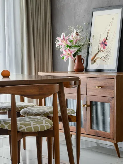 A closer look at the custom crockery unit and dining set from the 'Poorna' project, showcasing the warm wood tones and timeless design.