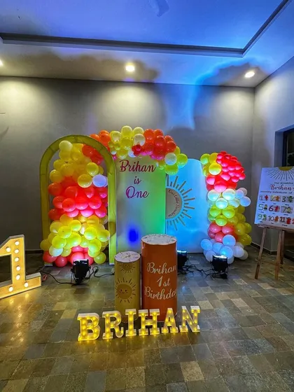 The Sunshine theme setup under different lighting, showing the marquee letters and personalized plinths.