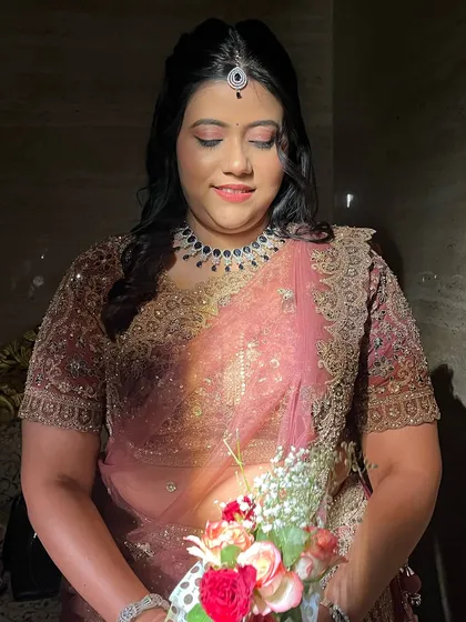 The dramatic lighting highlights the dewy finish of her makeup.