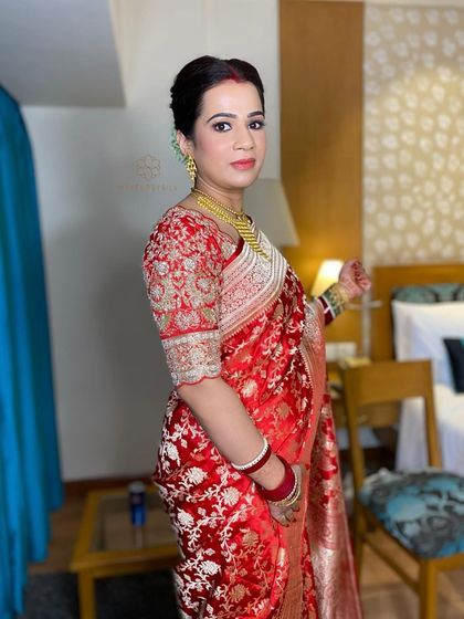 A classic look for a classic beauty. This Bengali bride looks stunning in her red Banarasi saree, with her hair styled in a neat bun.