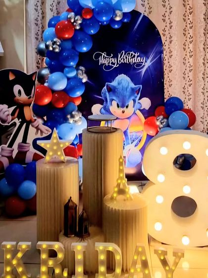 A Sonic the Hedgehog themed birthday party. This setup features a dynamic backdrop with Sonic, character cutouts, and a blue and red balloon garland for a high-speed celebration.