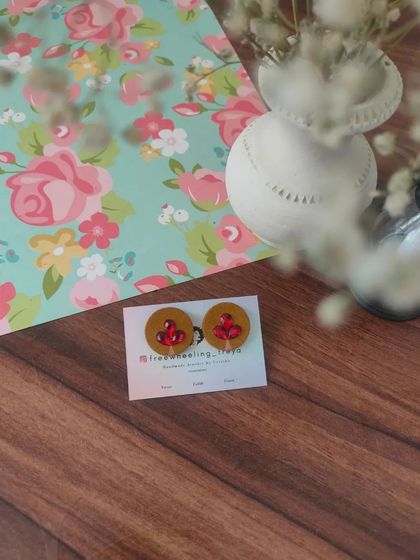 A collection of my simple and elegant fabric studs. Each pair is hand-painted with a small leaf motif and comes in a variety of colors like green, white, yellow, blue, and pink.