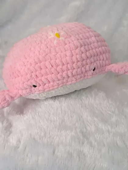 Another view of the adorable pink whale pillow, showcasing its soft, plush texture and friendly, hand-stitched eyes.