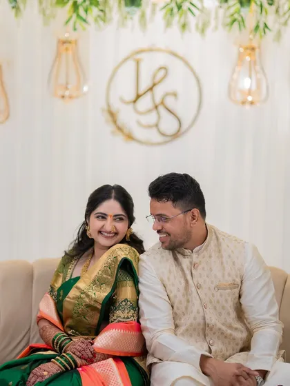 A sweet moment with Jagruti and Shubham seated in front of their custom monogram. This shot captures the personalized details of their engagement decor.