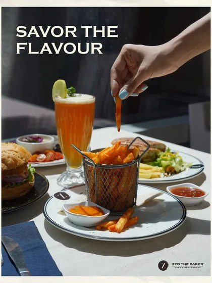 I believe in savoring every flavor. Here, a crispy French fry is dipped into ketchup, with a juicy burger and a refreshing drink completing the perfect meal.