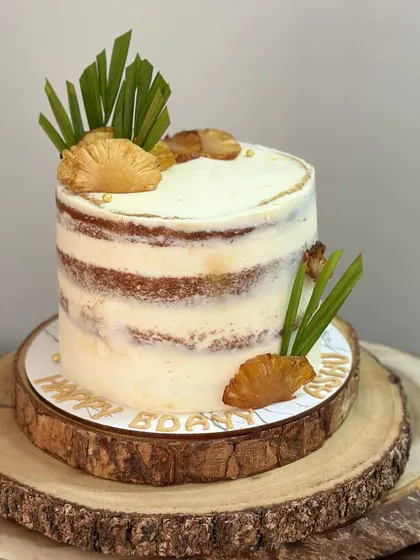 The full view of the rustic semi-naked cake, presented on a beautiful wooden slice stand.