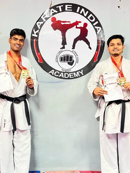 Two of my top athletes, Jeetu and Harshit, displaying their medals and certificates at our academy. Dressed in their karate gi and black belts, they represent the dedication and success that is the hallmark of our training.