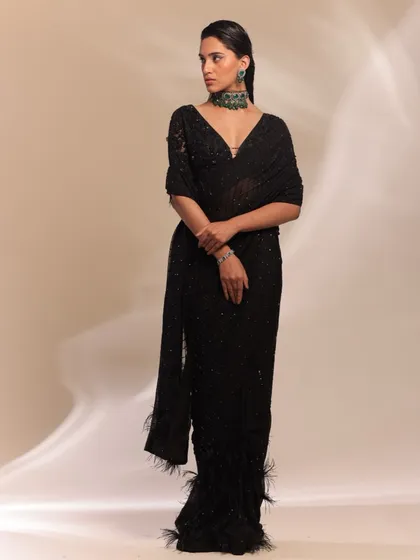 A black sequined saree with feather details offers a dramatic and chic option for a cocktail party or sangeet. I paired this modern drape with a bold emerald choker to create a focal point. This look is for the bride who wants to make an unforgettable, high-fashion statement.