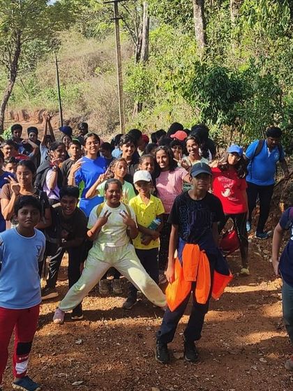 A happy group of trekkers poses for a photo on a dirt trail during their nature exploration at Barapole.