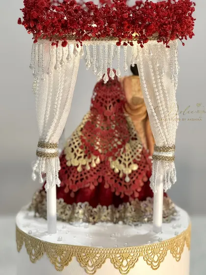 A close-up of the Mandap cake topper. Every detail, from the edible lace on the bride's lehenga to the hanging pearl strands, is crafted by hand.