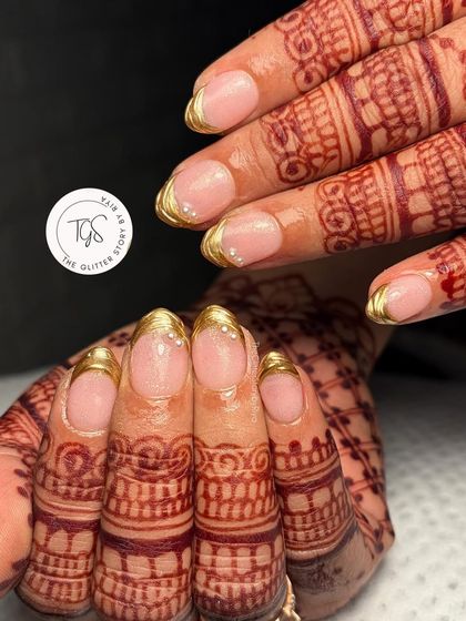 Simple, elegant, and perfect for a bride. These classic gold chrome tips on beautifully shaped nails are a timeless choice that looks stunning with traditional henna.