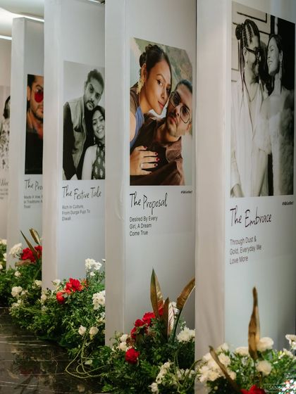 A close-up of the personalized panels that lined the entrance walkway. Each panel features a photo from the couple's history with a title like "The Proposal" or "The Embrace," turning the decor into a beautiful narrative of their love story.