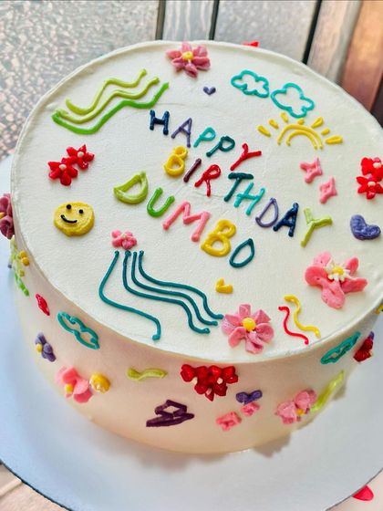 Holding up the custom doodle art cake. The design wraps all the way around the cake, making every angle a feast for the eyes.