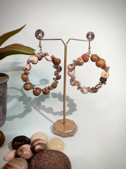 A product shot of the "Swings of Seashore" statement hoop earrings, made with natural stones.