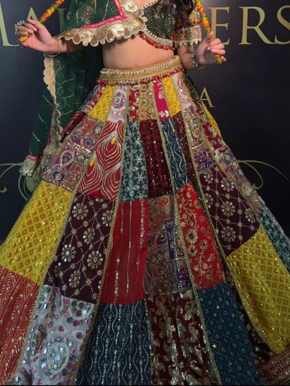 A detailed shot of the patchwork lehenga skirt. You can see the intricate embroidery and mirror work on each panel, making it a truly special piece.