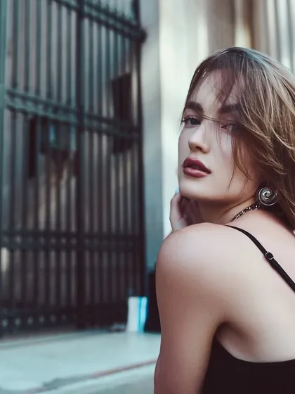 An on-location portrait with a cinematic feel. The shallow depth of field and the model's over-the-shoulder glance create a sense of story and intrigue.