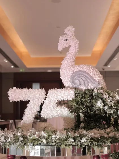 Personalization is key to making an event truly special. For a 75th birthday, we crafted this magnificent floral sculpture featuring the number "75" and an elegant swan, creating a unique and memorable welcome centerpiece for the celebration.
