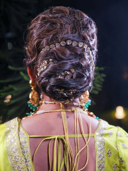 An elegant and intricate bridal bun. My mom accessorized this classic updo with beautiful golden hairpieces, creating a look that is both traditional and regal.
