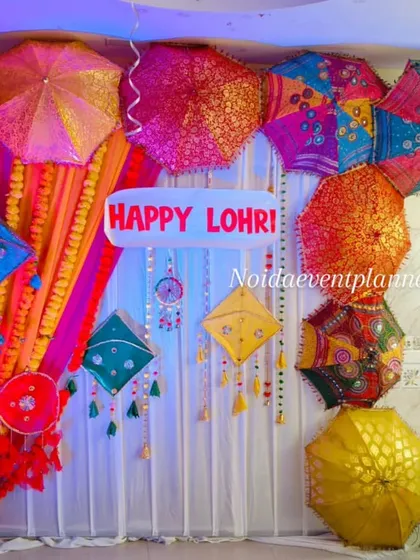 Another angle of our Lohri party decor, showing the 'Happy Lohri' sign and the rich textures of the colorful umbrellas and drapes.