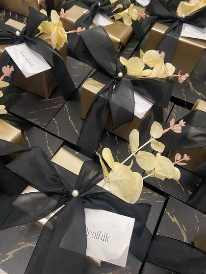 A collection of our sophisticated groomsmen favours. These black marble boxes are tied with an elegant black ribbon and a pearl, each with a personalized name tag for the members of the groom's crew.